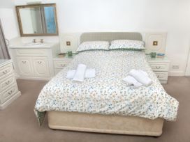 A bedroom with a bed and mirror at Weymouth Bay Apartment C in Greenhill