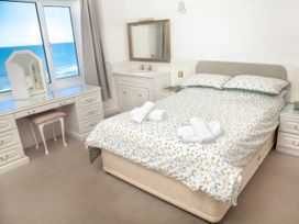 A bedroom with a bed and dressing table at Weymouth Bay Apartment C in Greenhill