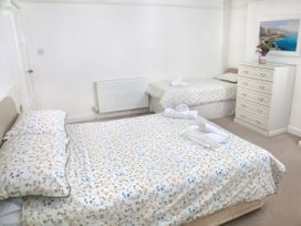 A bedroom with a double bed and twin bed at Weymouth Bay Apartment C in Greenhill