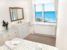 A bedroom with a bed and a dressing table at Weymouth Bay Apartment C in Greenhill