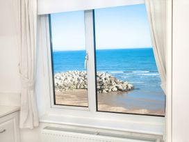 A window with a view of the ocean and rocks at Weymouth Bay Apartment C in Greenhill