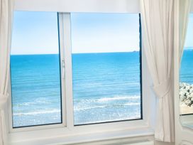 A window with a view of the sea at Weymouth Bay Apartment C in Greenhill