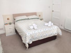 A bedroom with a bed and nightstand at Weymouth Bay Apartment C in Greenhill