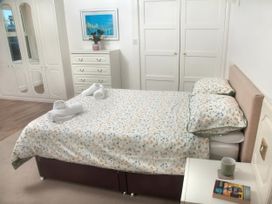 A bedroom with a bed and bedside table at Weymouth Bay Apartment C in Greenhill