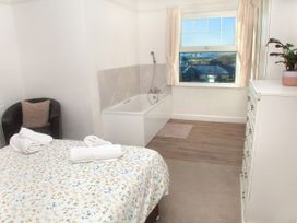 A bedroom with a bed and bathtub at Weymouth Bay Apartment C in Greenhill