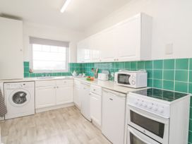 A kitchen with appliances and cabinets at Weymouth Bay Apartment C in Greenhill