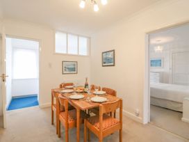 A dining room with a table set for meals at Weymouth Bay Apartment C in Greenhill