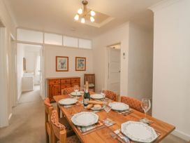 A dining room with a table set for a meal at Weymouth Bay Apartment C in Greenhill