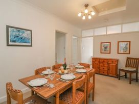 A dining room with a table set for a meal at Weymouth Bay Apartment C in Greenhill