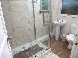 A bathroom with a shower, washbasin, and toilet at Weymouth Bay Apartment C Greenhill