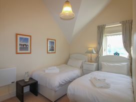 A bedroom with two beds and a nightstand at 16 Bolt Head in Salcombe