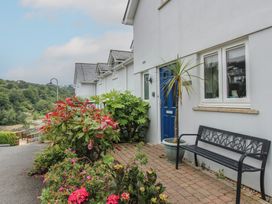 A house entrance with a bench and plants at 16 Bolt Head in Salcombe