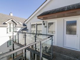 An outdoor balcony with glass railing and doors at 19 Bolt Head Salcombe
