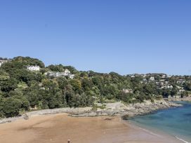 A beach with trees and houses along the coastline at 19 Bolt Head Salcombe