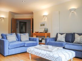 A living room with blue sofas and a coffee table at 1 Crabshell Quay in Kingsbridge
