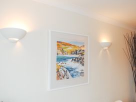 A wall with a framed artwork and light fixtures at 1 Crabshell Quay in Kingsbridge