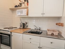 A kitchen with a sink, stovetop, and microwave at 1 Hazeldene in Salcombe