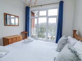 A bedroom with a bed and mirror at 1 Hazeldene Salcombe