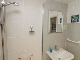 A bathroom with a shower, sink, and mirror at 1 Hazeldene in Salcombe