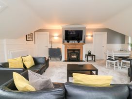 A living room with a fireplace and television at 1 The Old Coach House in Dartmouth