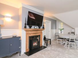 A living room with a fireplace and television at 1 The Old Coach House in Dartmouth