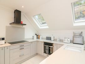 A kitchen with cabinets, stove, and various appliances at 1 The Old Coach House Dartmouth