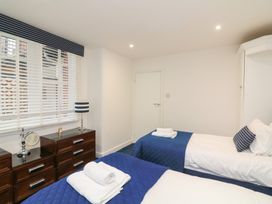A bedroom with two beds and a window at 1 The Old Coach House in Dartmouth