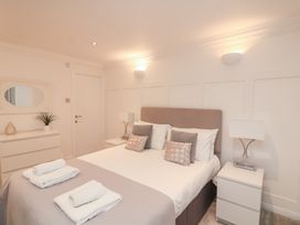A bedroom with a bed and dresser at 1 The Old Coach House in Dartmouth