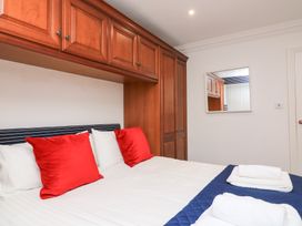 A bedroom with a bed and wooden cabinets at 1 The Old Coach House in Dartmouth