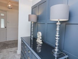 A hallway with lamps and a clock on a dresser at 1 The Old Coach House Dartmouth