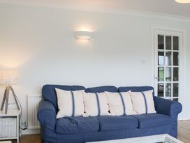 A living room with a blue sofa and cushions at 2 Poundstone Court in Salcombe