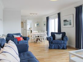 A living room with a sofa and dining area at 2 Poundstone Court in Salcombe