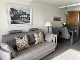 A living room with a sofa and dining area at 35 The Salcombe in Salcombe
