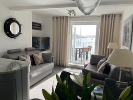 A living room with a sofa and view of water at 35 The Salcombe in Salcombe