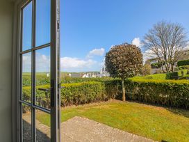 A view of a garden with a hedge and tree at 3 Combehaven in Salcombe