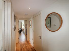 A hallway with a mirror and framed pictures at 3 Combehaven Salcombe