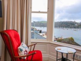 A living room with a red chair and a view of the harbor at 3 Dartview Dartmouth