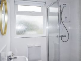 A bathroom with a shower, toilet, and mirror at 4 Lyndhurst, Salcombe