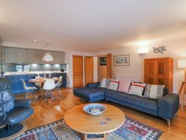 A living room with a sofa, table, and kitchen in 5 Dartmouth House Dartmouth