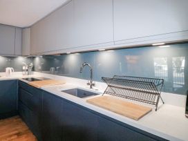 A kitchen with a sink and cutting board at 5 Dartmouth House Dartmouth