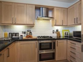 A kitchen with cabinets and appliances at 6 Combehaven in Salcombe