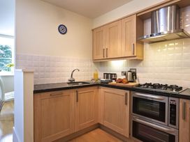 A kitchen with wood cabinets and appliances at 6 Combehaven in Salcombe