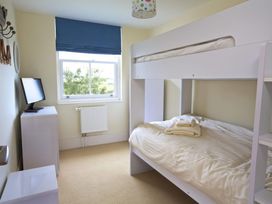 A bedroom with a bunk bed and television at 6 Combehaven in Salcombe