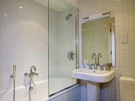 A bathroom with a bathtub and sink at 6 Combehaven Salcombe