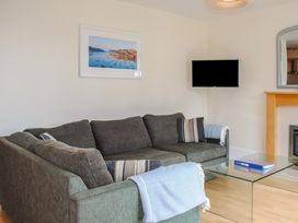 A living room with a sofa and a television at 6 Combehaven Salcombe