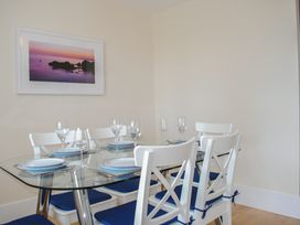 A dining room with a glass table and chairs at 6 Combehaven in Salcombe
