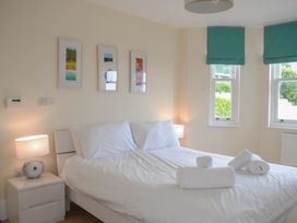 A bedroom with a bed and wall art at 6 Combehaven in Salcombe