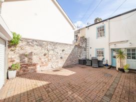 A courtyard with a stone wall and furniture at 7 Charles Street Dartmouth