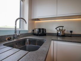 A kitchen with a sink, kettle, and toaster at 7 Thurlestone Rock in Thurlestone