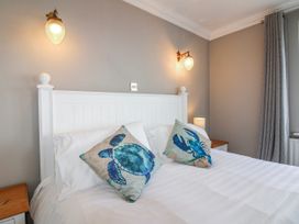 A bedroom with a bed and decorative pillows at 7 Thurlestone Rock in Thurlestone
